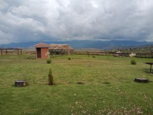 ein Feld mit einer Hütte in der Mitte eines Feldes in der Unterkunft Twilight Breeze Lodge in Phuthaditjhaba