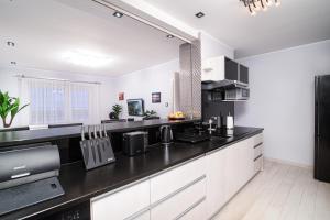 a kitchen with white cabinets and a black counter top at Apartament w Helu in Hel
