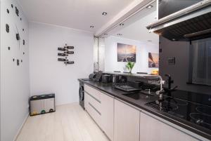 a kitchen with white walls and black counter tops at Apartament w Helu in Hel