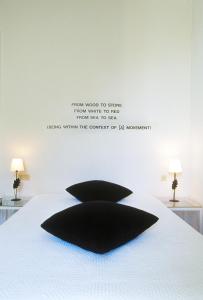 a bedroom with a black pillow on a white bed at Le Windsor, Jungle Art Hotel in Nice