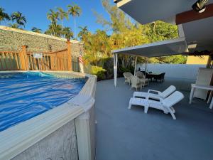 a patio with a swimming pool next to a house at Cozy MIA Airport Pool Home in Miami