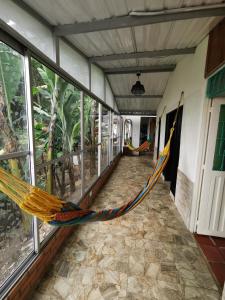 a hammock in a room with windows at CASA DE CAMPO CORRALEJAS - ANOLAIMA in Anolaima