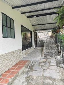 a building with awning and a stone walkway at CASA DE CAMPO CORRALEJAS - ANOLAIMA in Anolaima