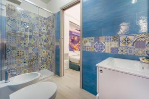 a bathroom with a sink and a toilet and blue tiles at La casa del postino in Procida +78 photos