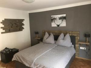 a bedroom with a bed with a black and white comforter at Appartement Brettljause Ferienhaus Fuenf Sinne in Döbriach