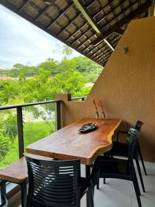 une table et des chaises en bois assises sur un balcon dans l'établissement Eco Resort Praia dos Carneiros - Flat 218 CM, à Tamandaré