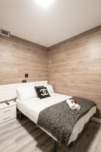 - une chambre avec un grand lit blanc et des murs en bois dans l'établissement Apartamentos Day Madrid CHUECA Centro Gran Via Sol Malasaña, à Madrid