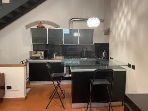 a kitchen with a counter and some chairs in it at Loft Ponte Pietra in Verona