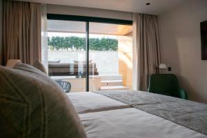 a hotel room with a bed and a large window at TenSuites - Adults Only in Maspalomas