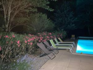 - une rangée de chaises et une piscine dans le jardin dans l'établissement Maison avec piscine chauffée entre mer et montagne, à Montauriol