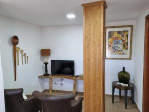 a living room with two chairs and a television at Casa da Andorinha in Pardieiros