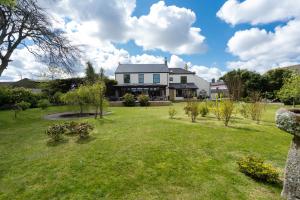 a house with a large yard with grass and trees at The Cedars in Redruth