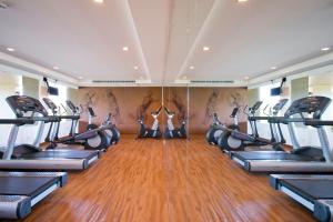 a gym with a row of treadmills and people in it at Sunsuri Phuket - SHA Plus in Nai Harn Beach