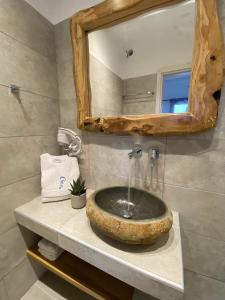y baño con lavabo de piedra y espejo. en Chill Out Studio, en Mykonos ciudad