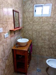 y baño con lavabo, espejo y aseo. en Cabaña Curacó en Santa Rosa