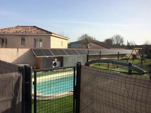 um campo de ténis atrás de uma cerca com um parque infantil em Chalet piscine montech em Montech