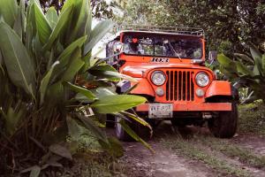 un jeep naranja estacionado en un camino de tierra en Tukawa Hotel en Filandia