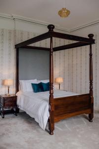 a bedroom with a canopy bed with blue pillows at Noan Country House B&B in Cashel
