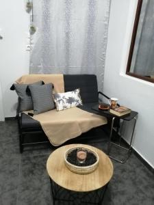 uma sala de estar com um sofá e uma mesa em Comfortbnb -Sabbia Calda 8 em Perissa