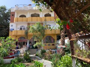 un bâtiment avec un jardin en face dans l'établissement The Mango Guest House, à Assouan