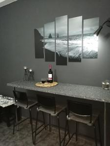 einen Tisch mit 4 Stühlen und eine Flasche Wein in der Unterkunft Comfortbnb -Sabbia Calda 8 in Perissa