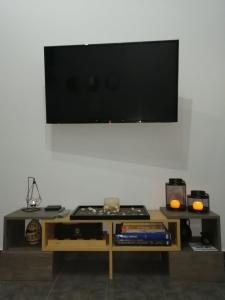 ein Wohnzimmer mit einem Tisch und einem Flachbild-TV in der Unterkunft Comfortbnb -Sabbia Calda 8 in Perissa