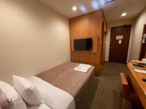 una camera d'albergo con letto e TV di Hotel Relief SAPPORO SUSUKINO - Vacation STAY 22951v a Sapporo