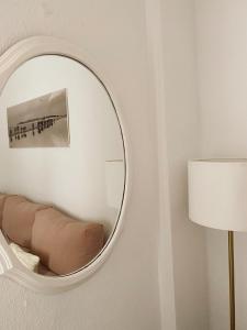 a mirror on a wall with a couch and a lamp at Casa Teté in Tarifa