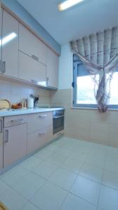 une cuisine avec des placards blancs et une fenêtre dans l'établissement M&L Lux 3-bedroom apartment (sea view), à Budva