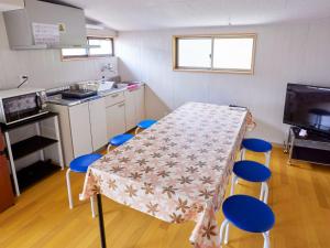 een kleine keuken met een tafel en blauwe stoelen bij Hanareya - Vacation STAY 27238v in Tsushima