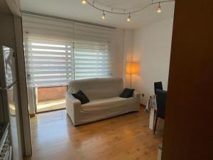 a living room with a white couch and a window at Apartament Neptuno Platja d'Aro in Platja  d'Aro