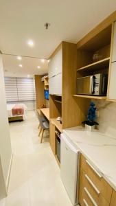 une cuisine avec un comptoir blanc et une chambre dans l'établissement Estudio Em Itaipava - Granja Brasil - Flat Luxo - Com Piscina Aquecida, à Itaipava