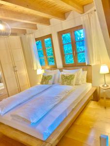 duże białe łóżko w pokoju z oknami w obiekcie Ferienwohnung Diana w mieście Sexau