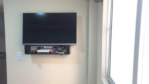 a flat screen tv hanging on a wall at Hermosos apartaestudios con WIFI in Bogotá