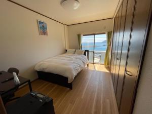 a bedroom with a bed and a view of the ocean at Coast house Nabura - Vacation STAY 29534v in Nagasaki