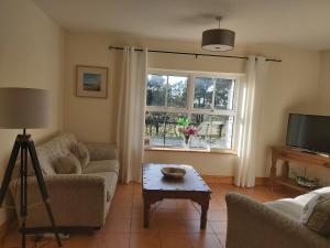 a living room with a couch and a table and a window at Shanakeever Farm - 2 Bedroom Apartment in Clifden