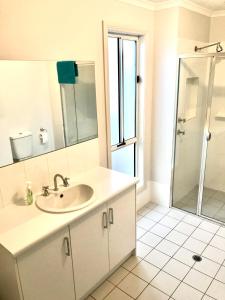 a white bathroom with a sink and a shower at Moontana in Port Moonta