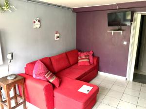 un divano rosso in un soggiorno con TV di Parisian Forest a Cesson