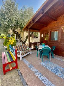 patio z krzesłami, stołem i ławką w obiekcie Chalet del girasole w mieście Castellabate