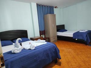 a hotel room with two beds and towels on a bed at Hotel Nuevo Amanecer Malabrigo in Puerto Chicama