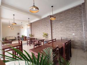 a restaurant with wooden tables and chairs and a brick wall at Hotel Nuevo Amanecer Malabrigo in Puerto Chicama