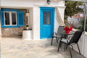 une maison avec une porte bleue, une table et des chaises dans l'établissement Anna's Lovely House, à Hydra