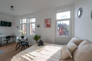 a bedroom with a bed and a table and windows at Résidence Kyjay in Cambrai