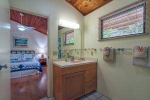 a bathroom with a sink and a bedroom with a bed at Poipu Plantation Vacation Rentals in Koloa +161 photos