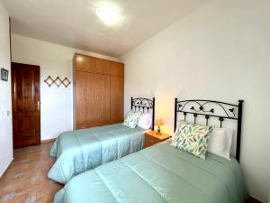 Casa María - Finca Medina في Alojera: غرفة نوم بسريرين في غرفة
