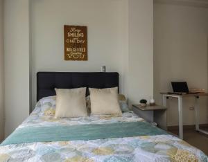 a bed with two pillows and a sign on the wall at Hermoso Apartamento Central in Pereira