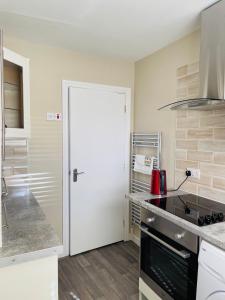 a kitchen with a white door and a counter top at Malvern Apartment in Derry Londonderry