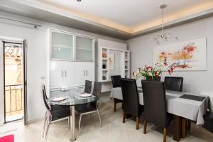 a dining room with a glass table and black chairs at Casa Corfiota in Corfu Town