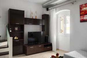 a living room with a flat screen tv on a wooden entertainment center at Casa Corfiota in Corfu Town