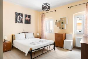a bedroom with a bed and two windows at Casa Corfiota in Corfu Town